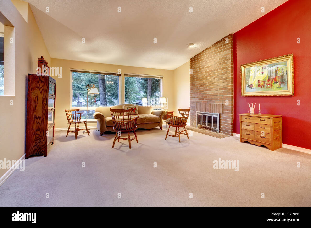 Grand salon avec cheminée en brique et mur rouge. Banque D'Images