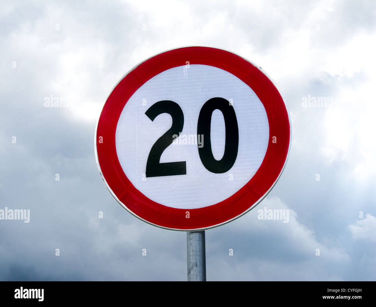Signe de la limite de vitesse 20 sur un poteau contre ciel nuageux Banque D'Images