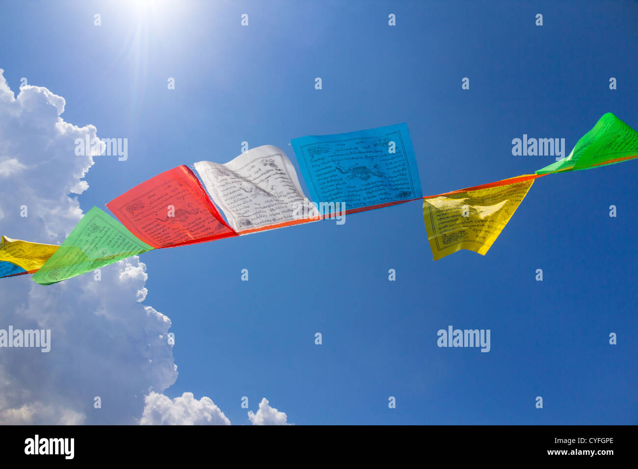 Quelques drapeaux de prière tibetains bouddhiste contre le ciel bleu avec un nuage Banque D'Images