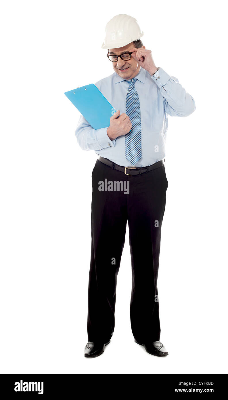 L'aîné architect posing in style comme il regarde son document d'entreprise Banque D'Images