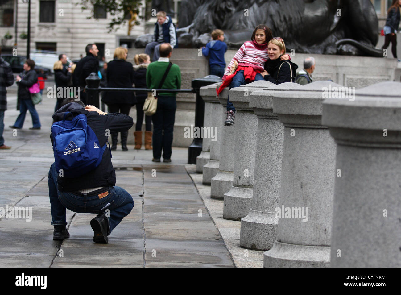 Un homme prend une photo d'une dame et l'enfant à Trafalgar Square Banque D'Images