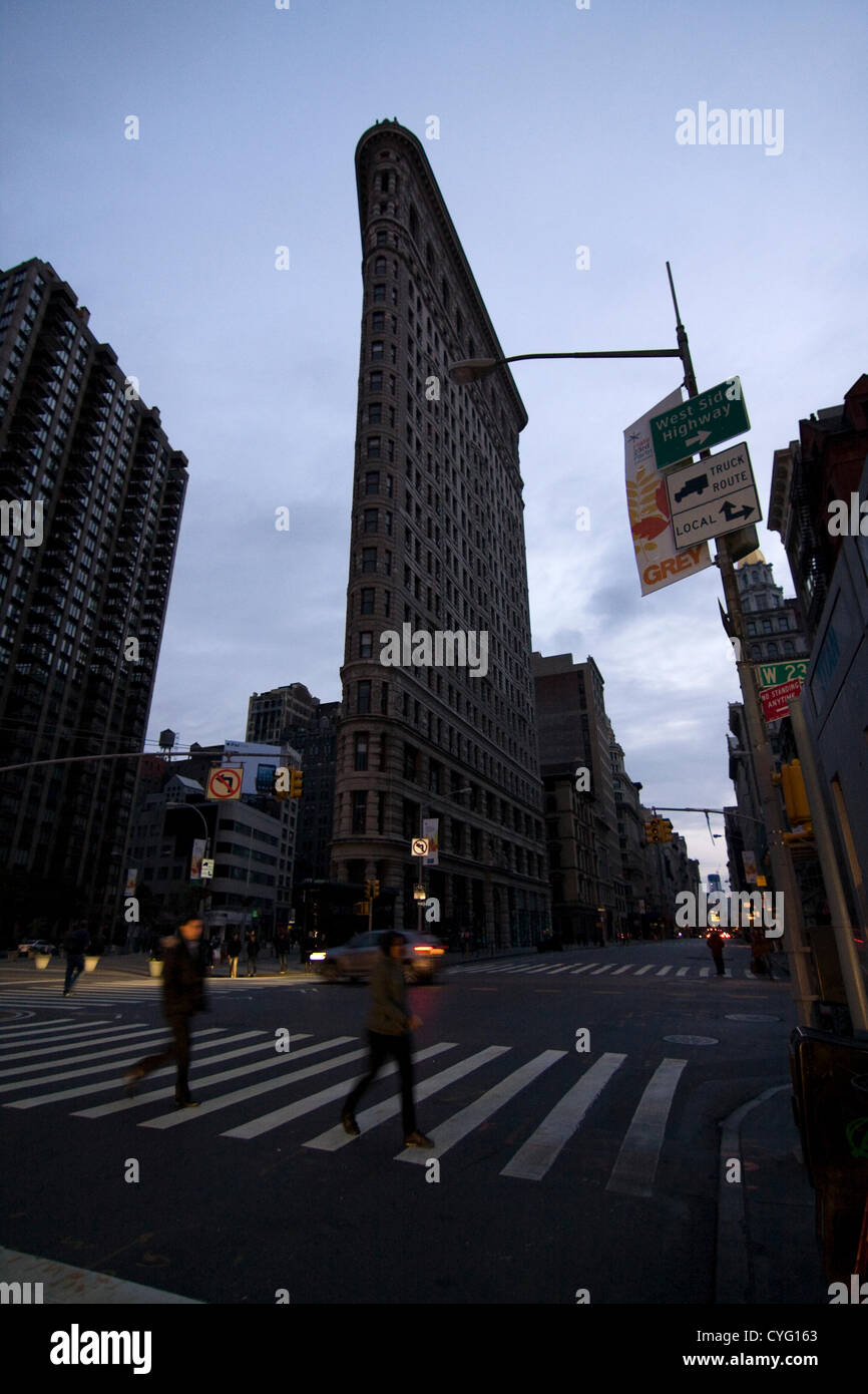 New York USA. 1er novembre 2012. En regardant vers le sud sur la 5e Avenue et 23e Rue, dans le quartier de Chelsea, New York City. L'emblématique Flatiron Building avec l'absence d'éclairage dans les fenêtres comme les New-yorkais se précipitent dans le tableau de concordance de la 5ème avenue allumé seulement par des phares des véhicules. Lampadaires et feux sombres restent quatre jours après l'Ouragan Sandy, coupent l'alimentation de parties de la ville au-dessous de la 29ème rue. Banque D'Images