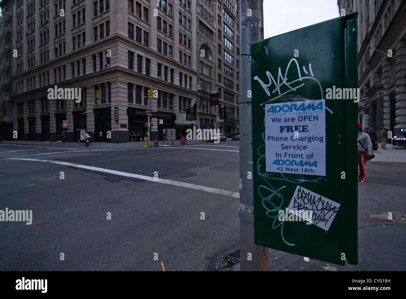 New York USA. 1er novembre 2012. En regardant vers le sud sur la 5e Avenue et 18e Rue dans le quartier de Chelsea, New York City. Un signe apposé sur un boîtier de commande de feux de circulation libre de publicité service de charge de téléphone alors qu'il y a une panne de courant à New York City à Adorama Camera Store. Lampadaires et feux sombres restent quatre jours après l'Ouragan Sandy, coupent l'alimentation de parties de la ville. Banque D'Images