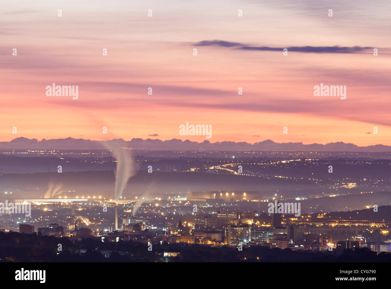 Paysage urbain industriel dans l'aube la lumière comme le soleil brille à l'horizon Banque D'Images