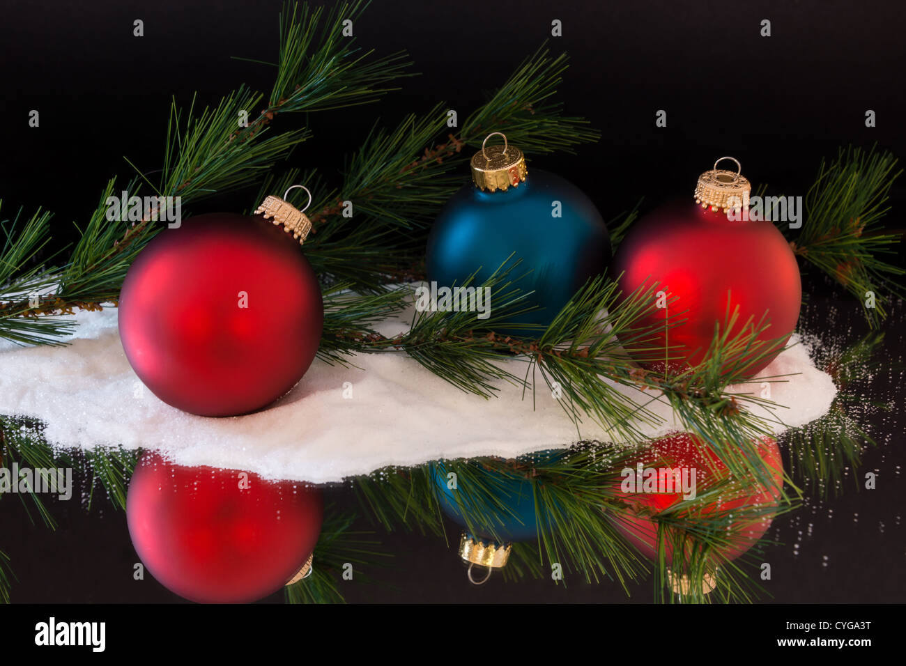 Les boules de Noël colorées s'asseoir entre les branches de pins et de neige Banque D'Images