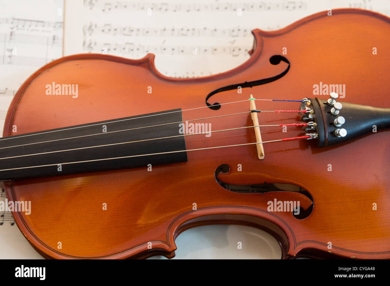 Un violon jette contre quelques vieilles partitions de musique. Banque D'Images