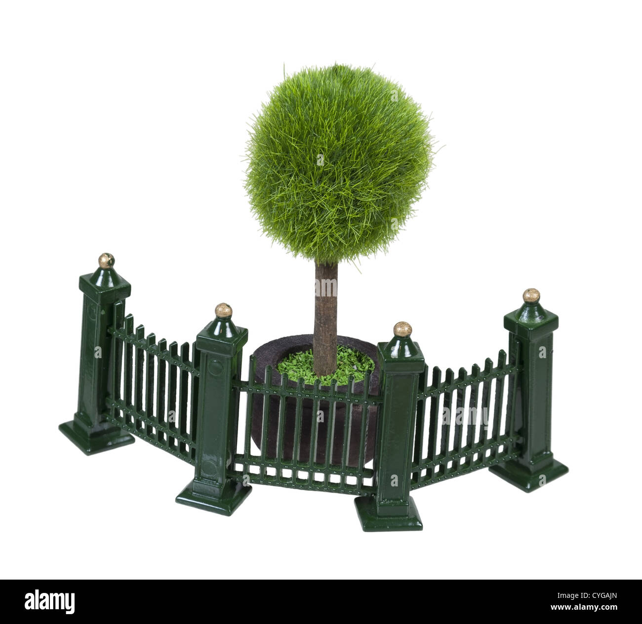 Clôture métallique avec volutes peint en vert en face d'un arbre en pot Banque D'Images