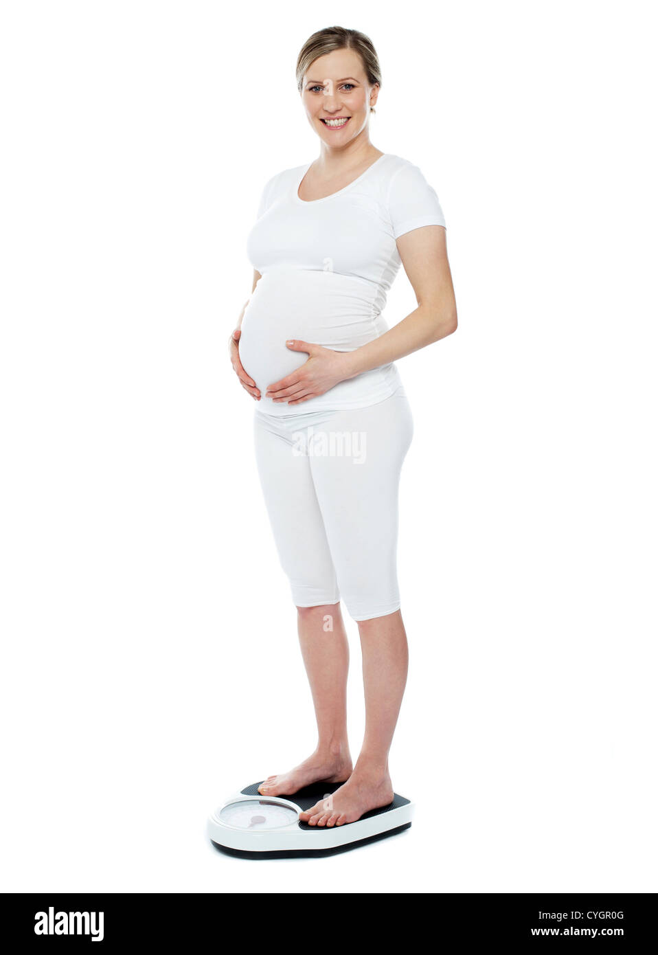 Femme enceinte la mesure de son poids au moyen de l'échelle de pesage. Mains sur l'estomac Banque D'Images