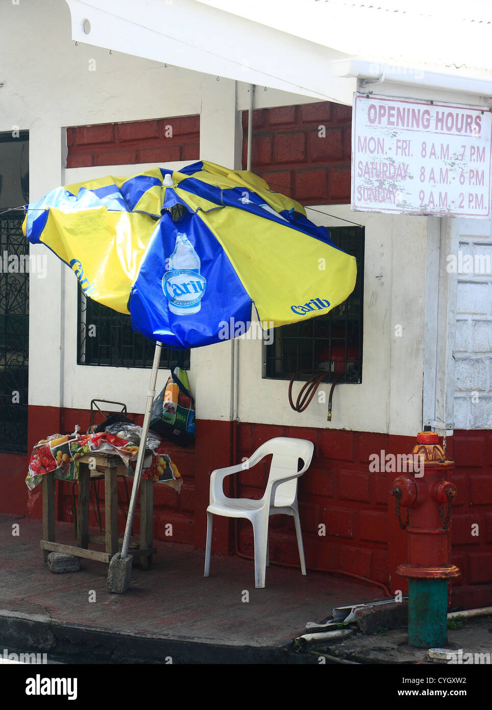 Un parasol jaune et bleu s'appuyant sur un vieux bâtiment blanc et rouge Banque D'Images