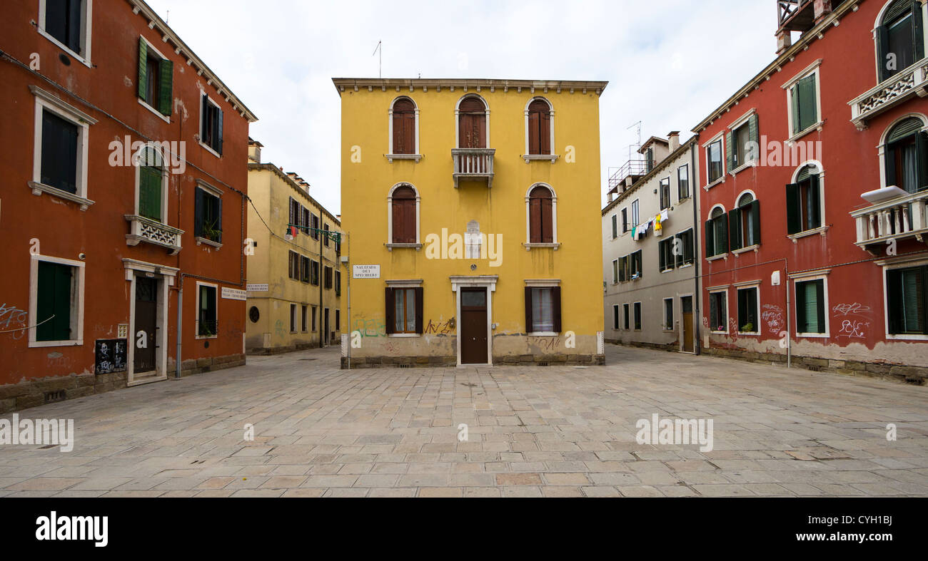 Maisons peintes en ocre rouge et jaune à l'extérieur de l'église catholique de Venise Gesuiti Banque D'Images
