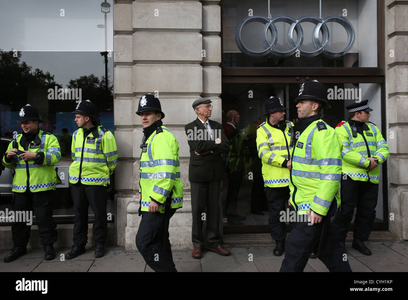 Stand de la police à l'extérieur d'une voiture de luxe d'exposition lors d'un Trade Union Congress (TUC) mars à Londres, Grande-Bretagne, 20 octobre 2012. Banque D'Images