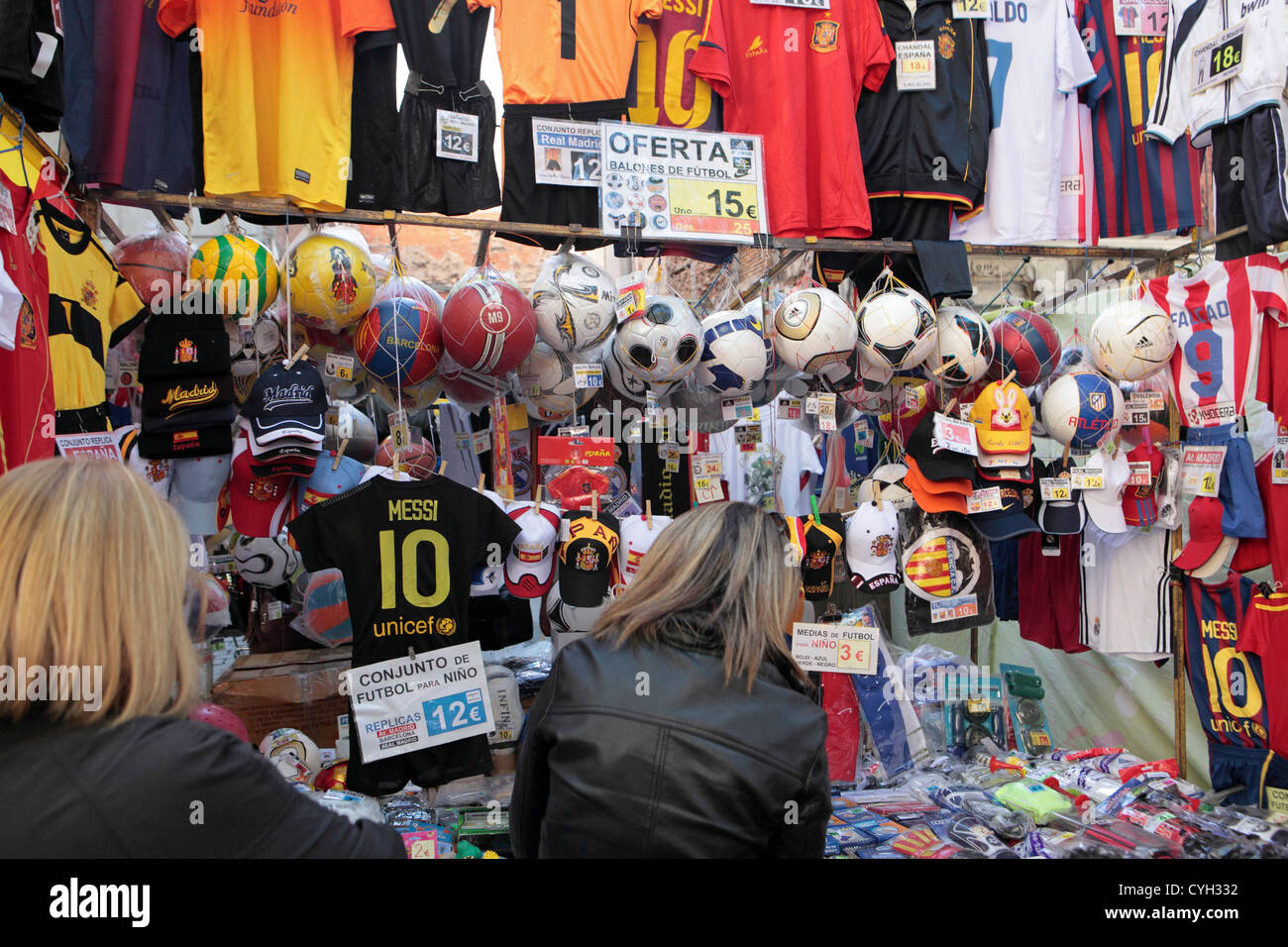 Deux femmes touristes shop pour le football club de souvenirs à vendre, El Rastro, dimanche street market, Madrid, Espagne Banque D'Images