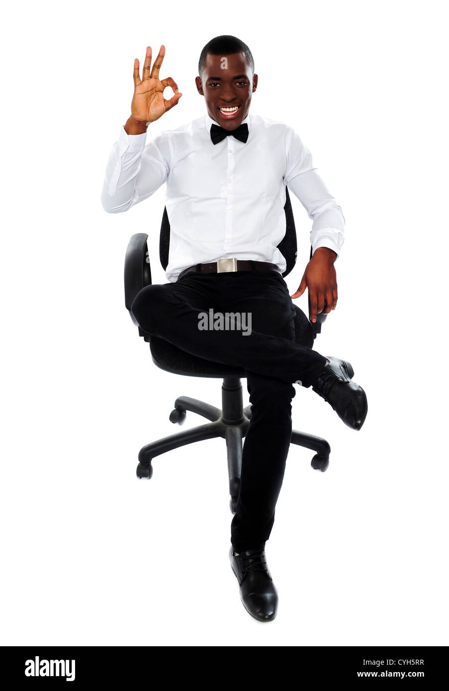 L'entreprise de l'Afrique de l'homme assis sur une chaise et montrant bien geste pour appareil photo Banque D'Images