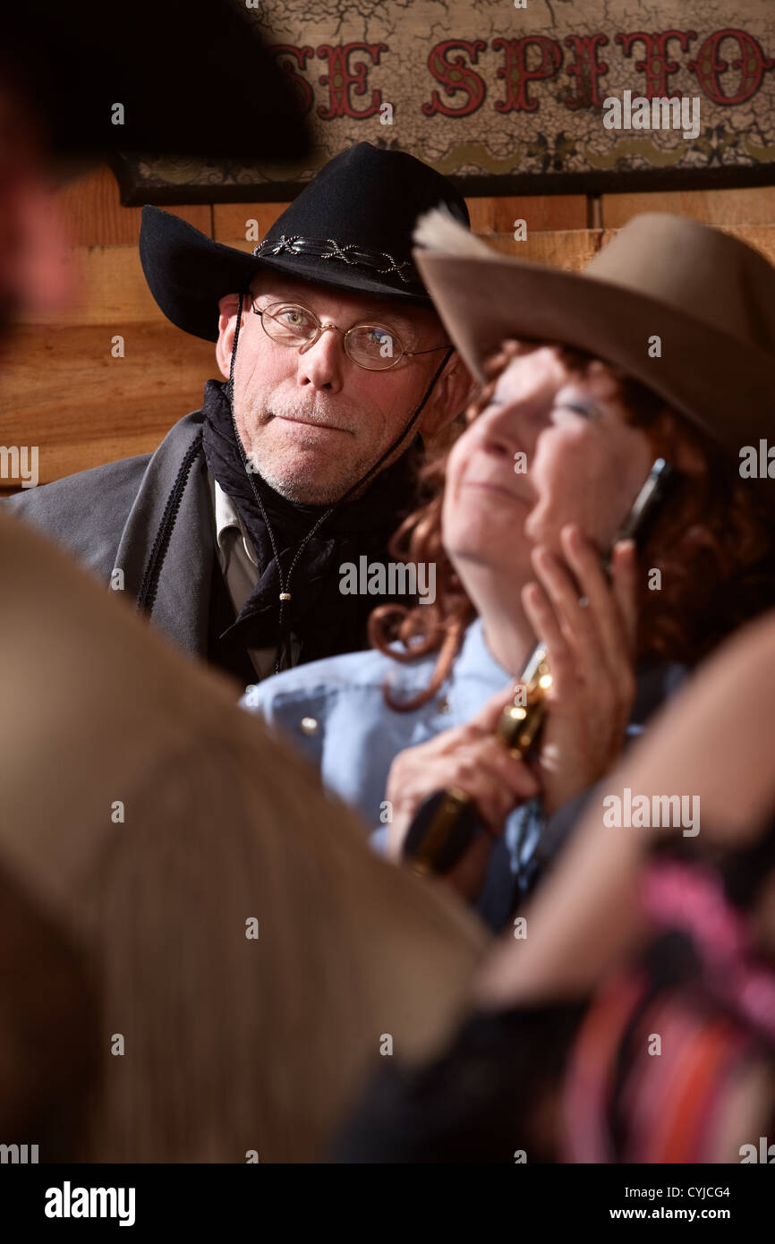 Smiling middle aged cowboy dans old American west saloon Banque D'Images