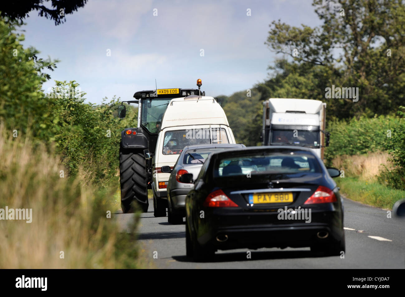 Traffic coincé derrière un tracteur sur une route dans le Gloucestershire UK Banque D'Images