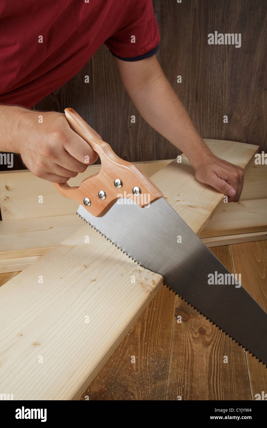 Atelier de bois. Carpenter planche de découpe avec scie à main. Banque D'Images