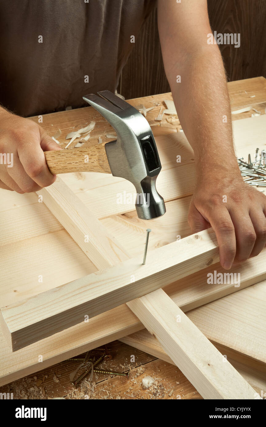 Atelier de bois. Carpenter marteler un clou. Banque D'Images