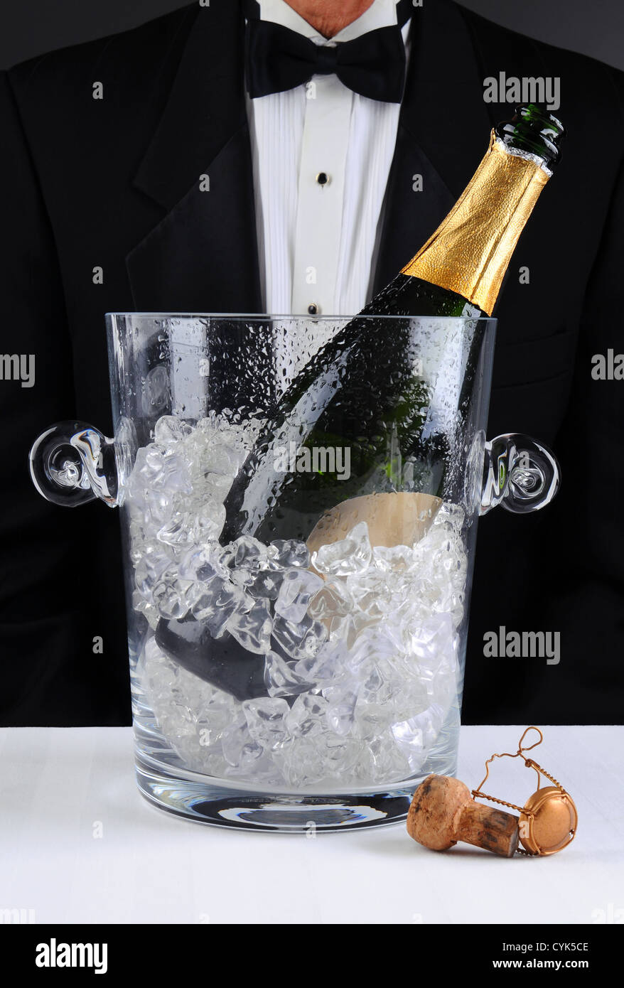 Libre d'un garçon debout derrière un seau à champagne, profondeur de champ à l'homme est méconnaissable. Format vertical. Banque D'Images
