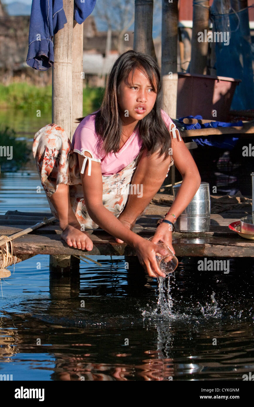 Le Myanmar, Birmanie. Girl lave-vitre dans l'eau du lac, lac Inle, l'État Shan. Banque D'Images