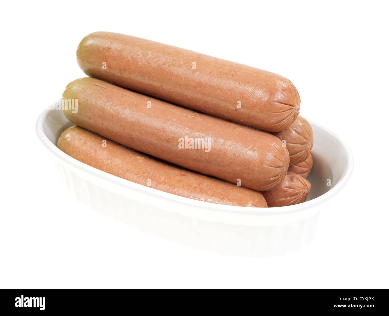 Bologne plusieurs saucisses dans un plat allant au four, sur un fond blanc. Banque D'Images