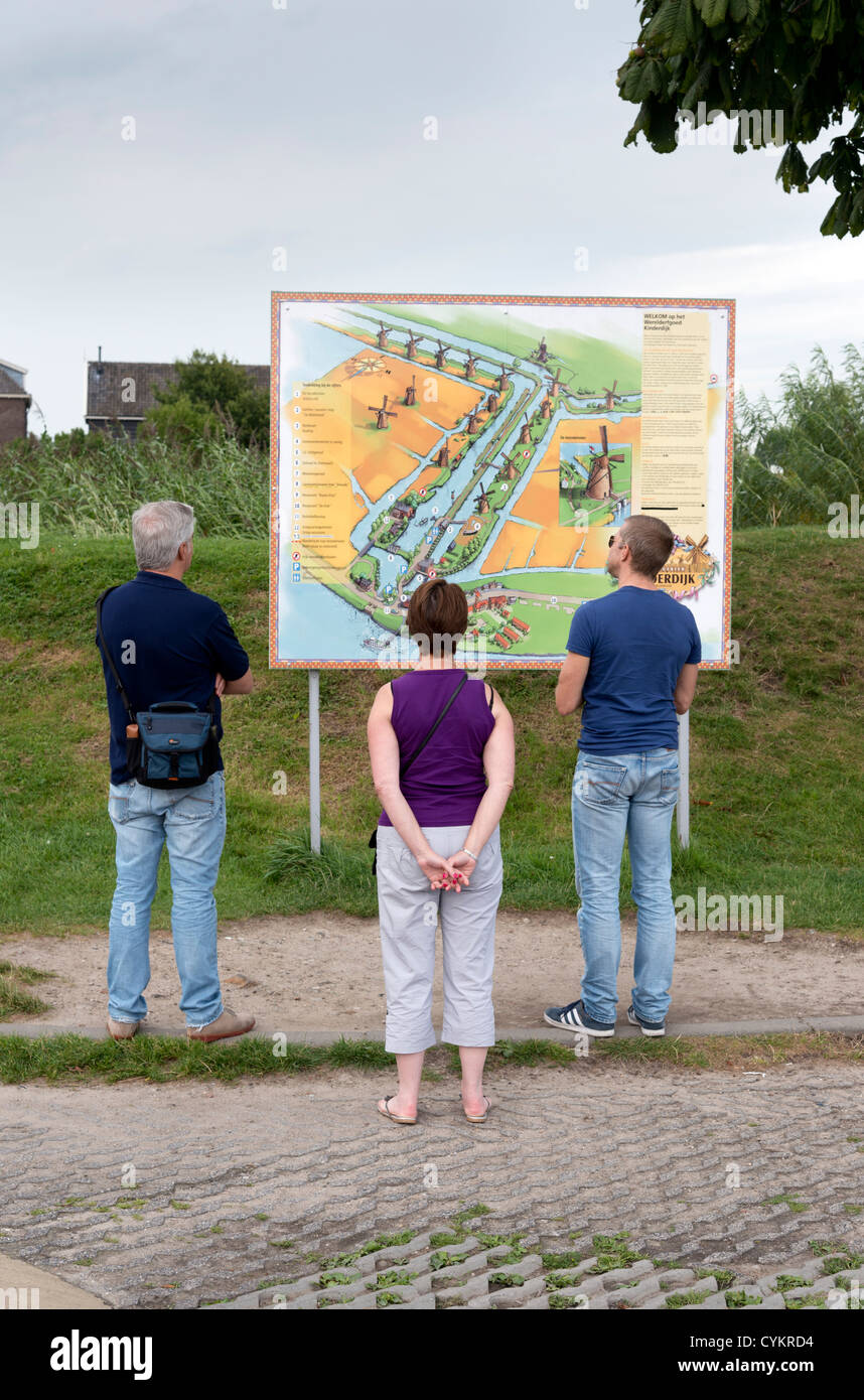 Un groupe de deux hommes et une femme à la recherche d'un guide touristique et carte de Kinderdijk Pays-Bas Banque D'Images