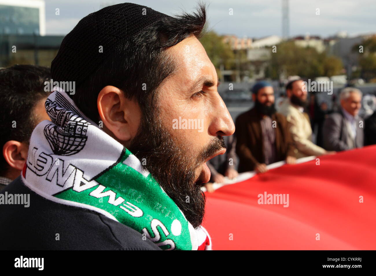Istanbul, Turquie. 6 novembre, 2012. Les partisans de la flotte de la liberté pour Gaza rassemblement en face du palais de justice d'Istanbul. Jeune homme avec barbe et chapeau de crâne criant des slogans, tout en brandissant un immense drapeau turc avec environ 50 autres manifestants. Les chants et les meneurs ont donné les milliers de manifestants ont suivi avec un bruit assourdissant. Credit : Johann Brandstatter / Alamy Live News Banque D'Images