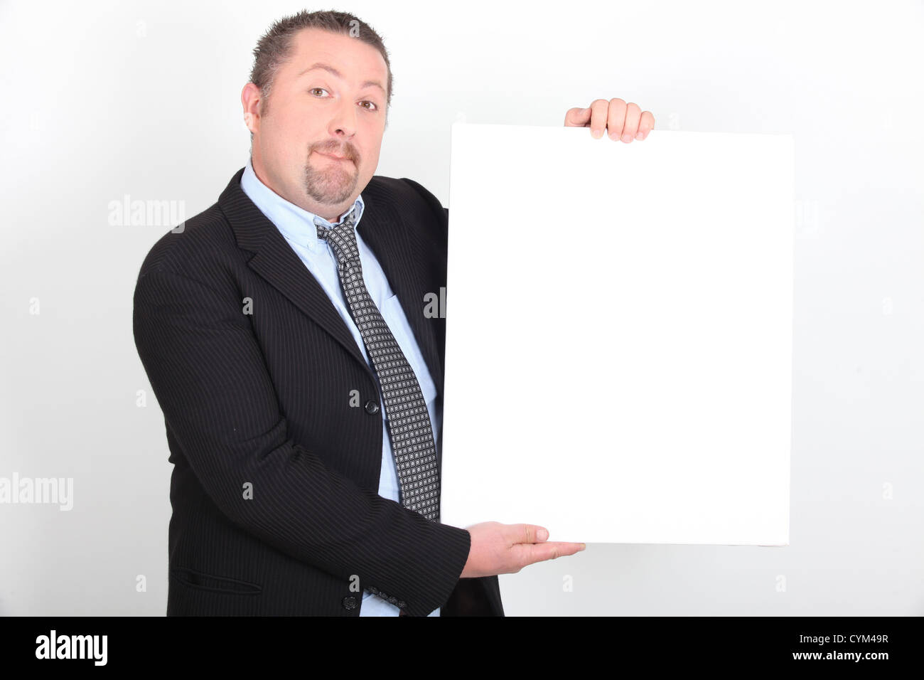 Man in suit holding white sign Banque D'Images