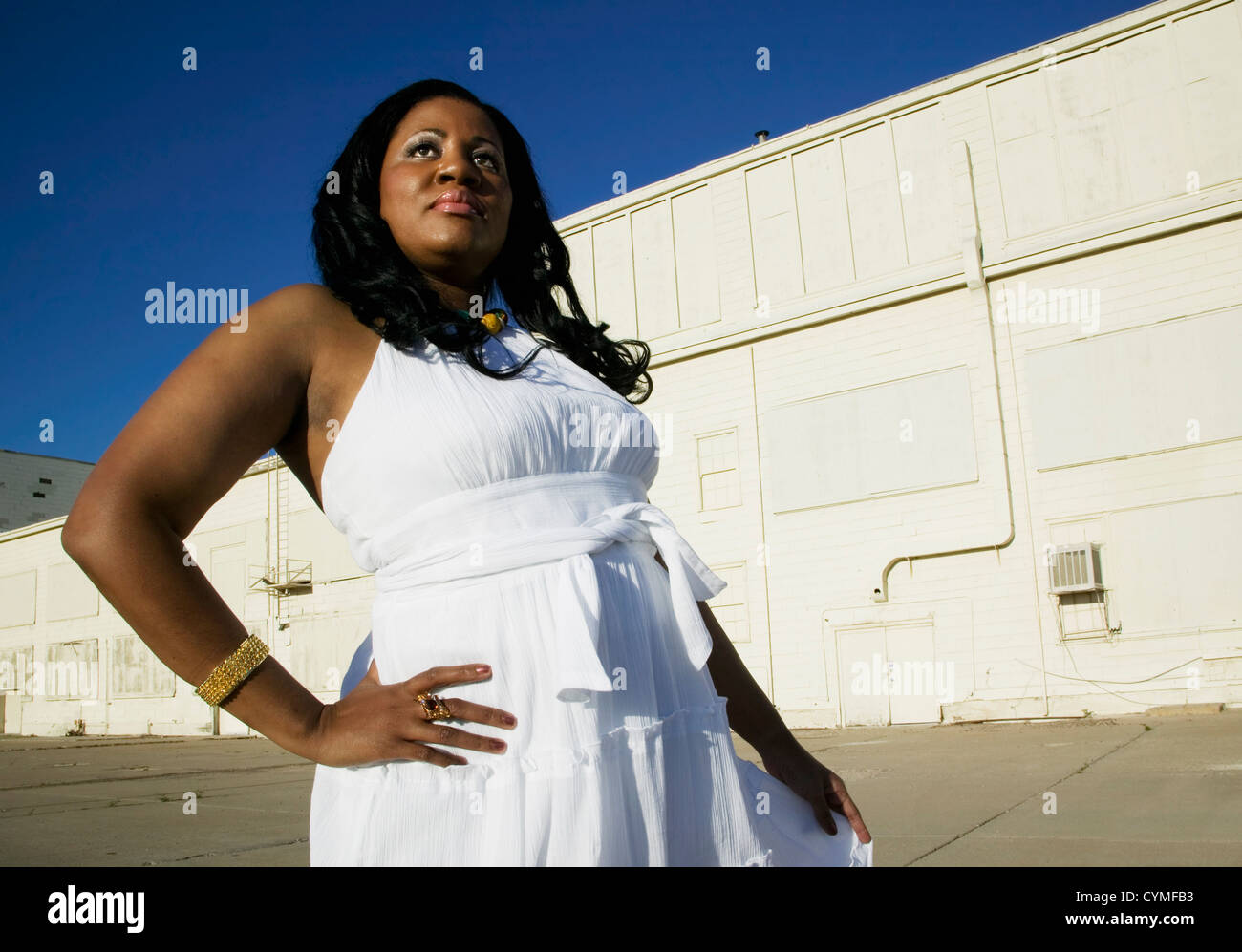 Plan moyen d'une femme afro-américaine à un bâtiment industriel. Banque D'Images