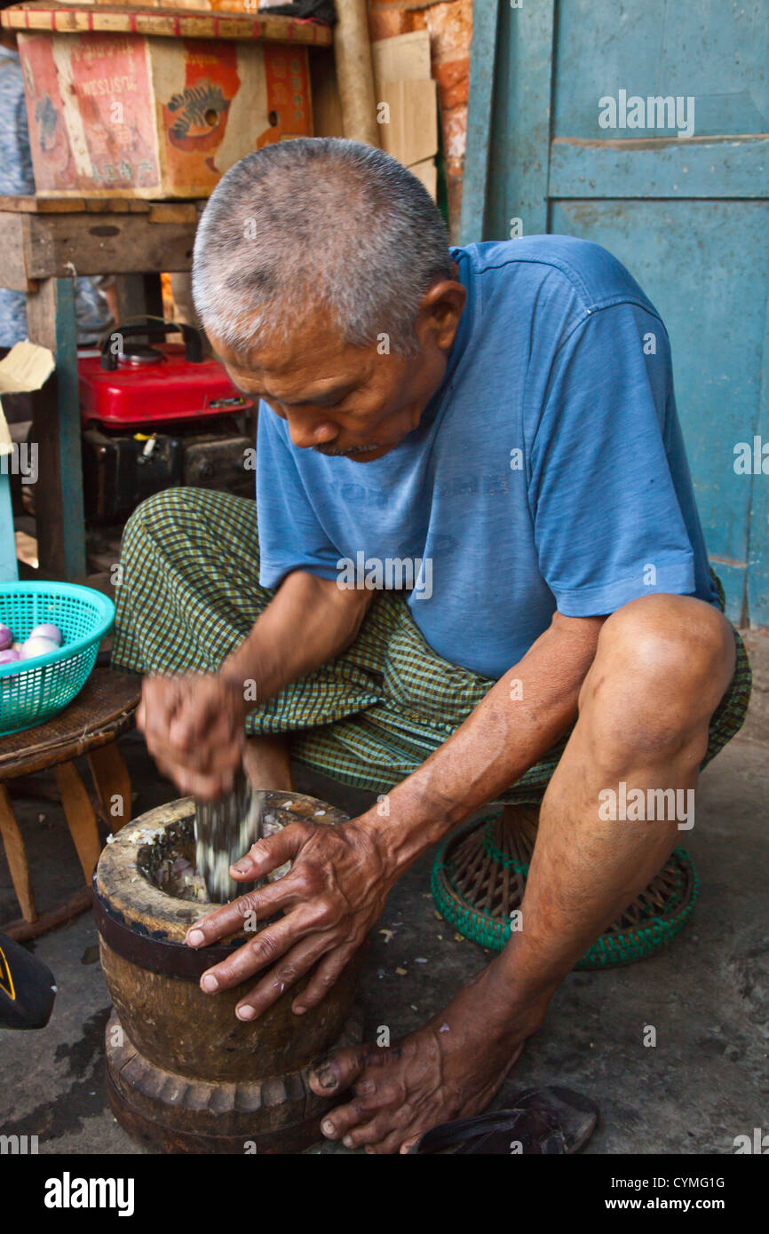 Un homme Birman à l'aide d'un mortier et pilon à KENGTUNG également connu sous le nom de KYAINGTONG - Myanmar Banque D'Images