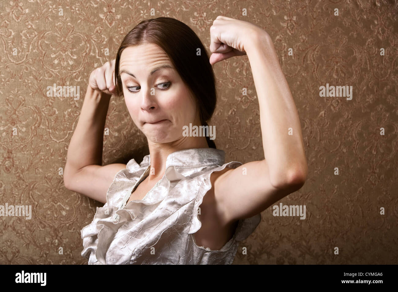 Jolie Jeune femme admirant sa flexion des biceps Banque D'Images