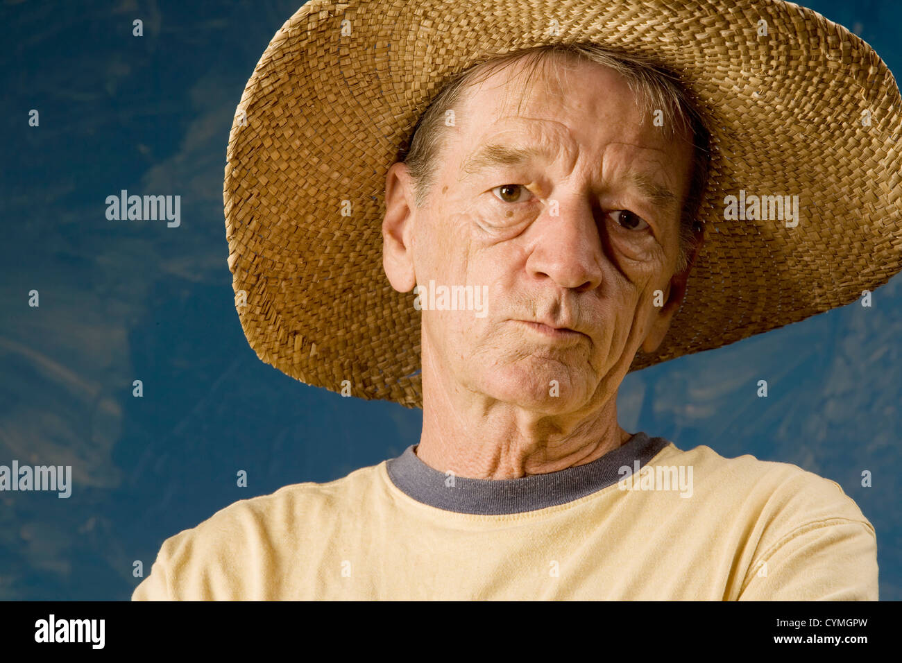 Man dans un chapeau de paille à l'avant du mur ensemble bleu Banque D'Images