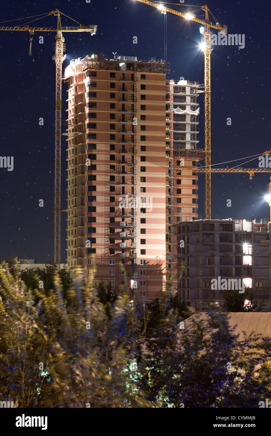 Chantier dans la nuit avec les grues de construction. Banque D'Images