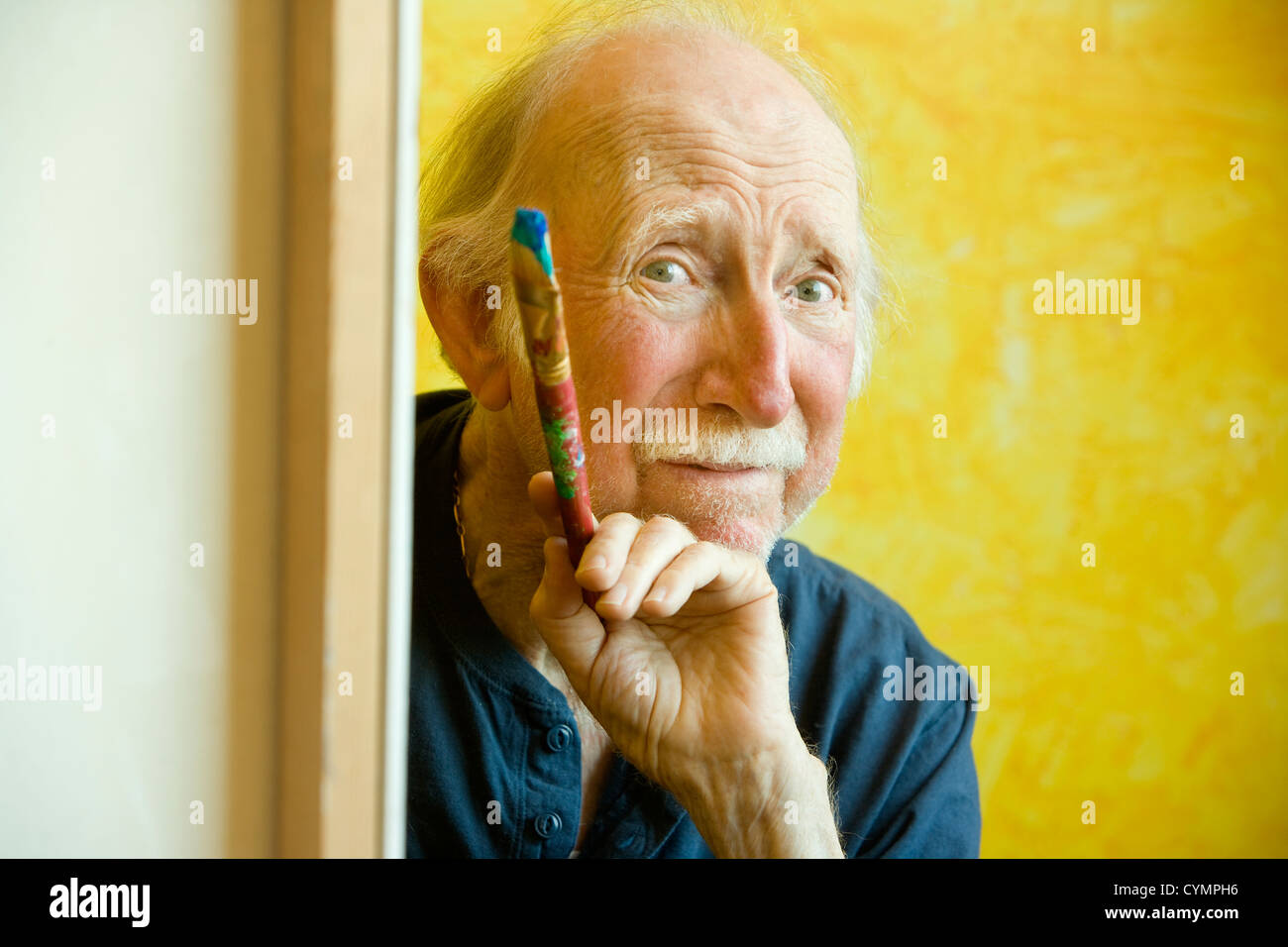 Peintre âgée travaillant sur une grande toile Banque D'Images