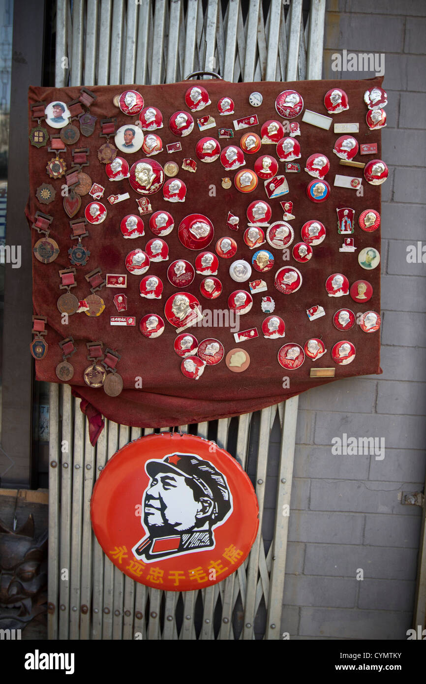Insigne communiste et insignes avec le président Mao sur l'affichage à une boutique dans une rue de Liulichang, Beijing, Chine. Banque D'Images