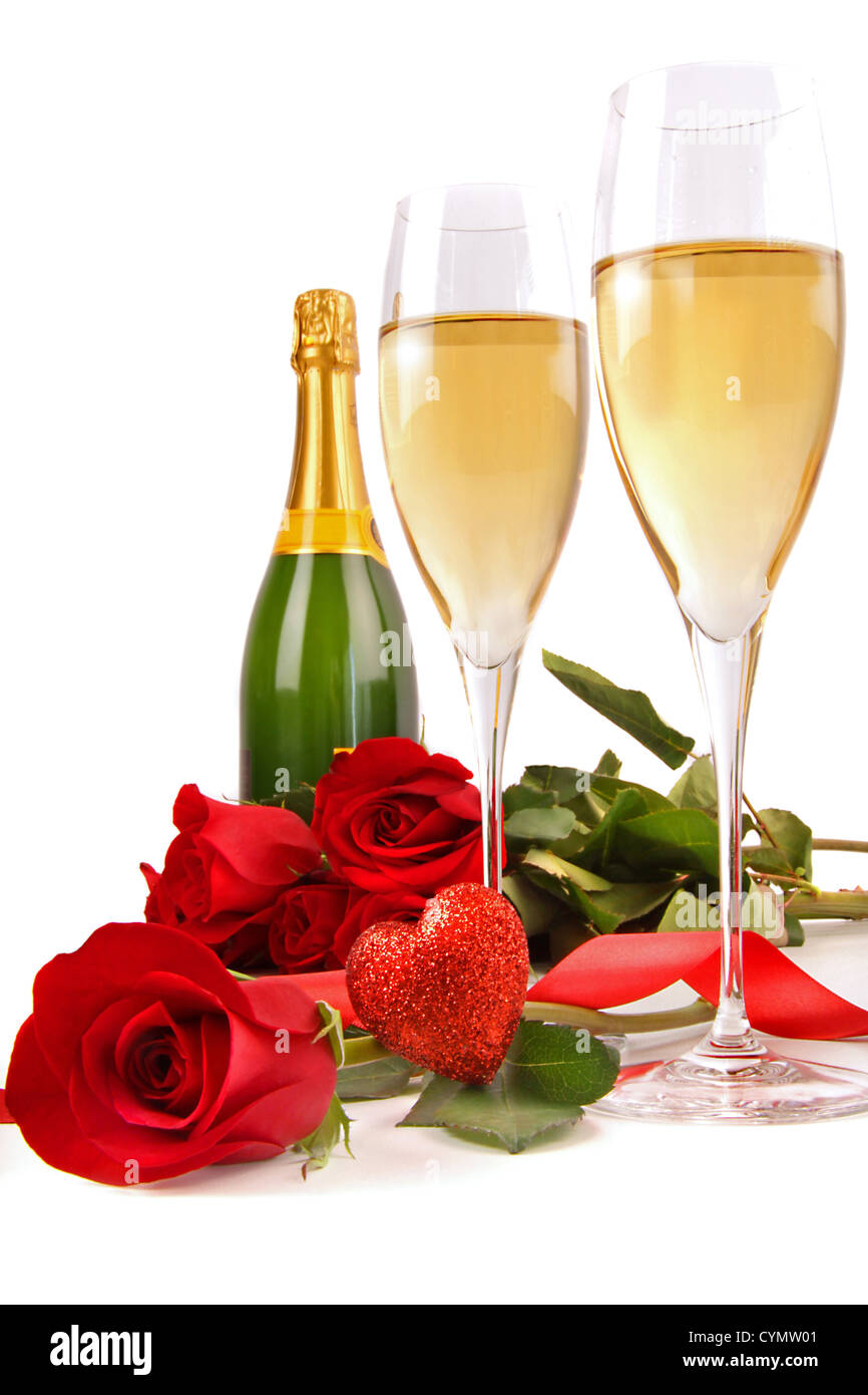 Verres de Champagne avec des roses rouges et petit coeur sur fond blanc Banque D'Images