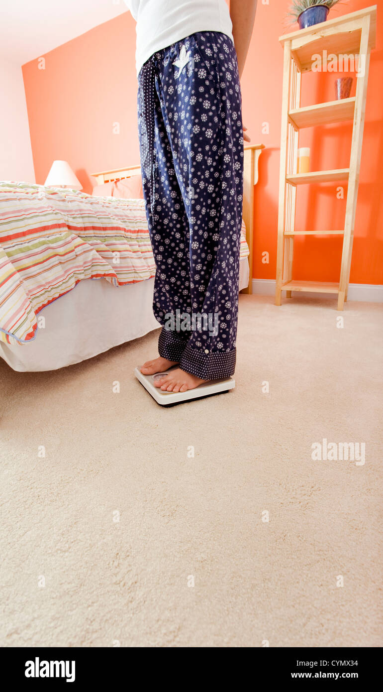 Portrait de femme debout sur une échelle à côté de son lit. Format vertical. Banque D'Images