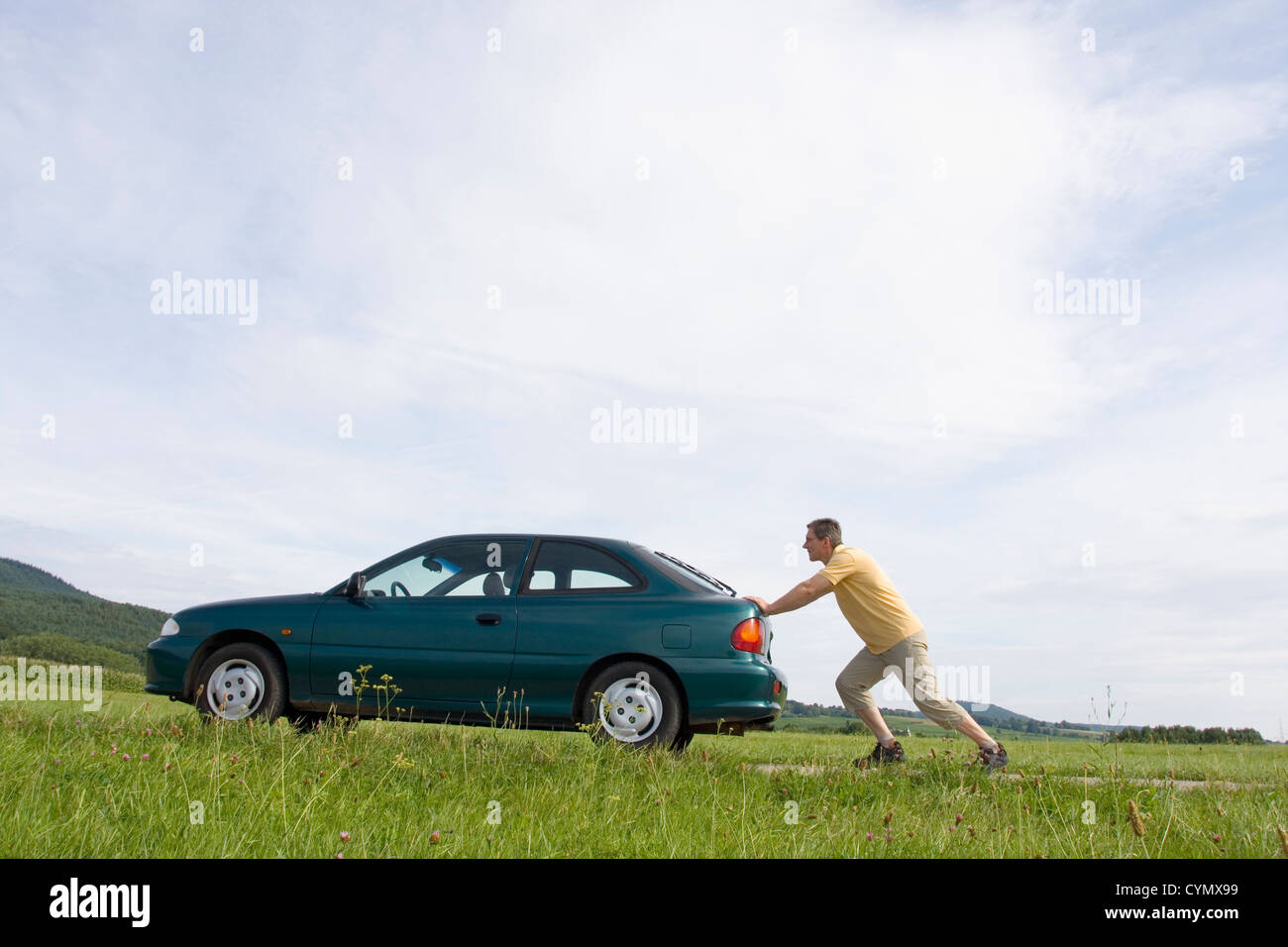 L'homme en poussant son automobile avec réservoir de carburant vide Banque D'Images