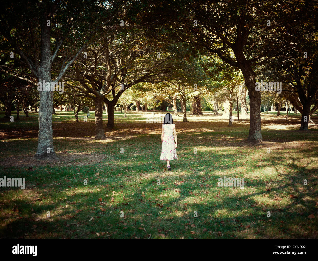 Fille marche parmi les arbres de parc. Banque D'Images