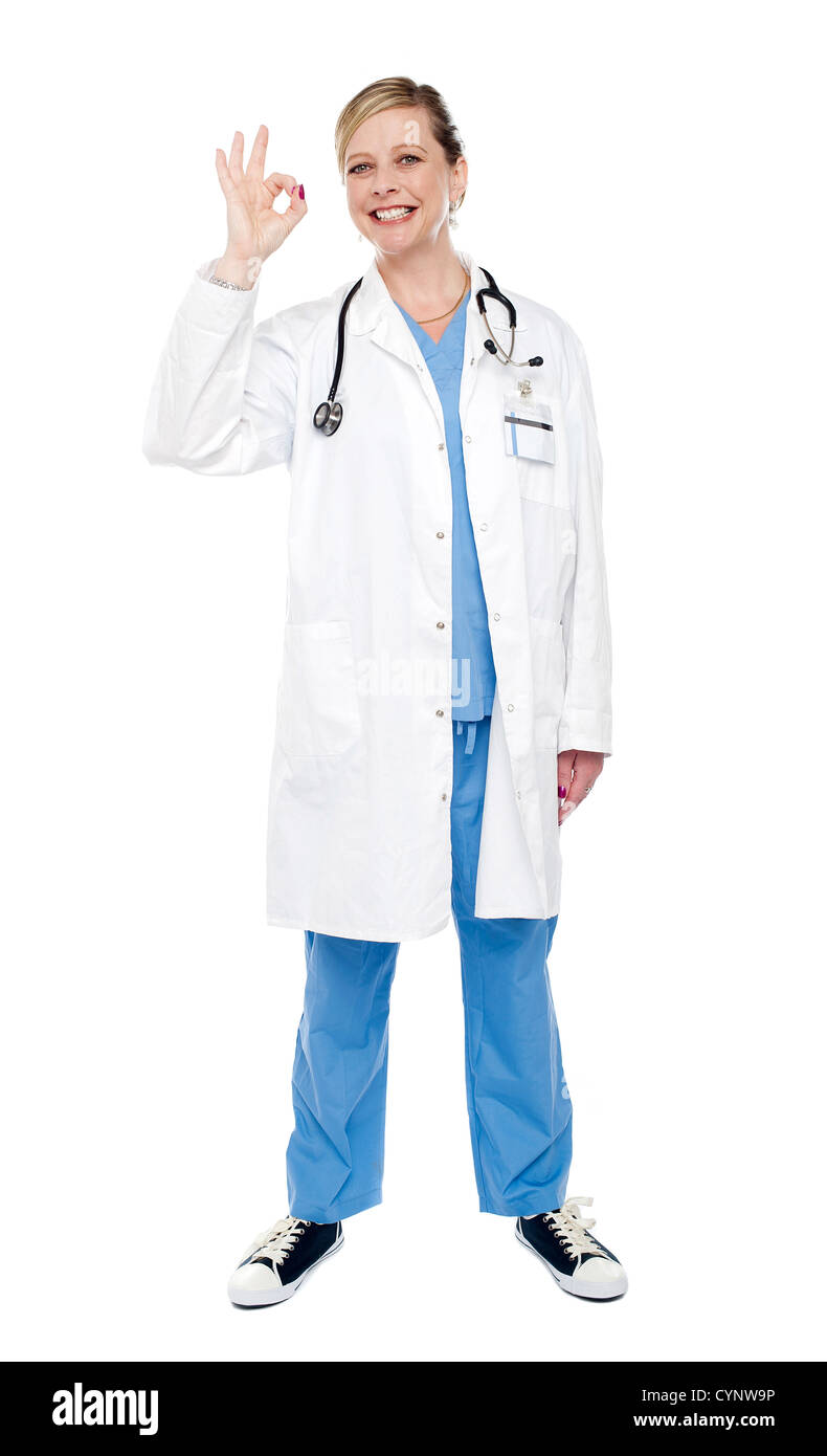 Femme médecin spécialiste gesturing ok sign isolated over white background. Shot pleine longueur Banque D'Images
