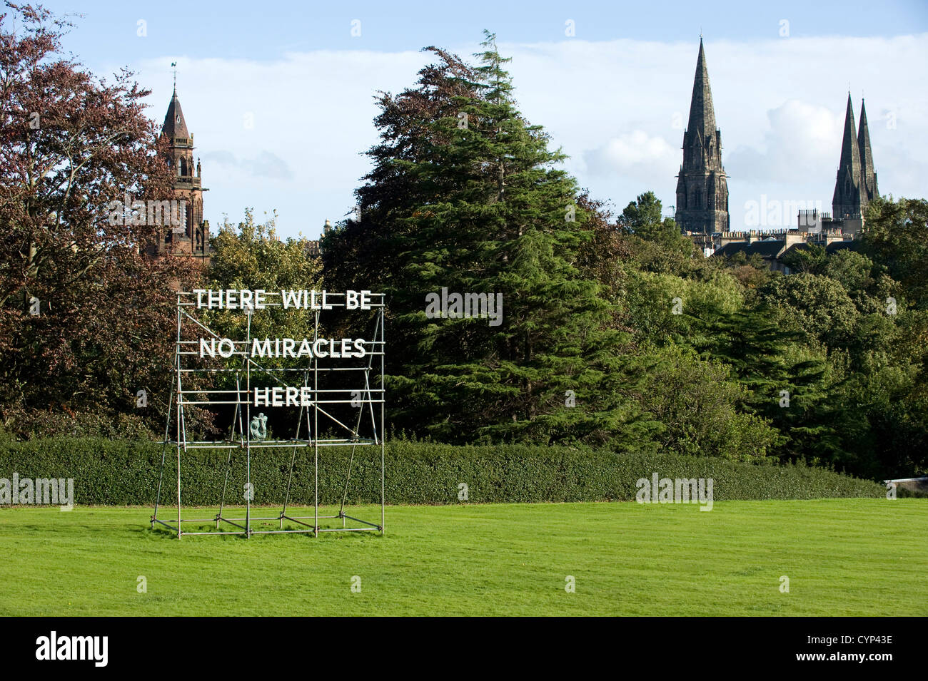 : Un "No miracles ici' dans les jardins de la Scottish National Gallery of Modern Art à Edimbourg, Ecosse avec trois clochers dans la ville derrière. C'est est une installation par l'artiste écossais Nathan Coley. Banque D'Images : Un "No miracles ici' dans les jardins de la Scottish National Gallery of Modern Art à Edimbourg, Ecosse avec trois clochers dans la ville derrière. C'est est une installation par l'artiste écossais Nathan Coley. Banque D'Images