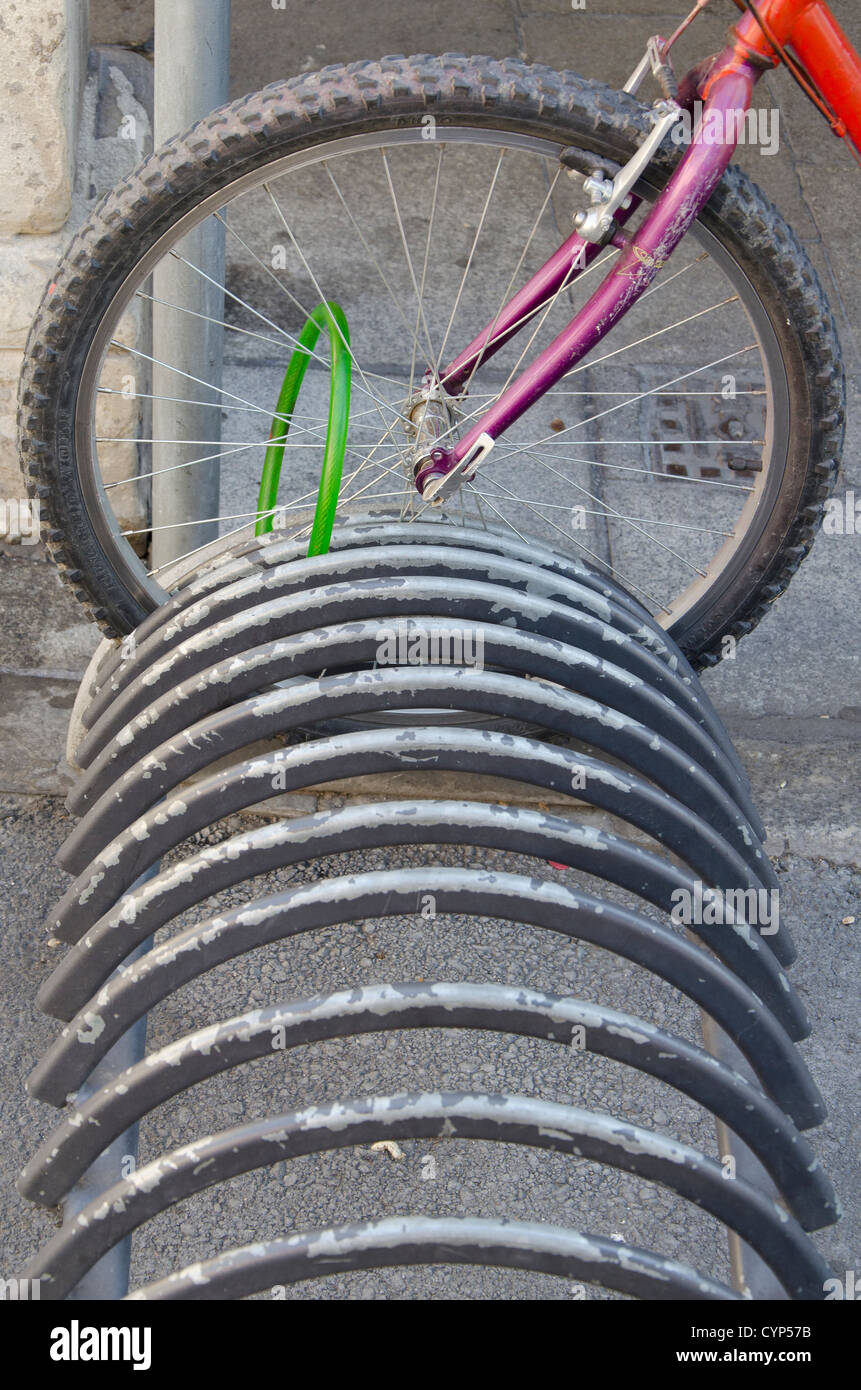 Roue de vélo dans un parc de stationnement pour vélos Banque D'Images