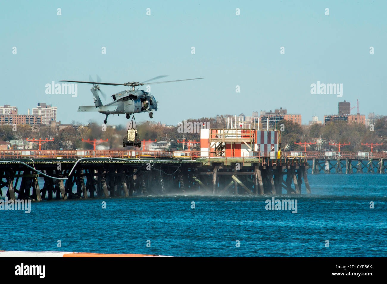NEW YORK (Nov 6, 2012) UN MH-60 de l'US Navy Sea Hawk affectés à l'Escadron d'hélicoptères de combat de la mer (HSC) 9 sling-charge un générateur de puissance de l'aéroport LaGuardia à une plate-forme à travers l'affaissement d'un pont d'accès. Wasp LHD (1), l'USS San Antonio (LPD 17) un Banque D'Images