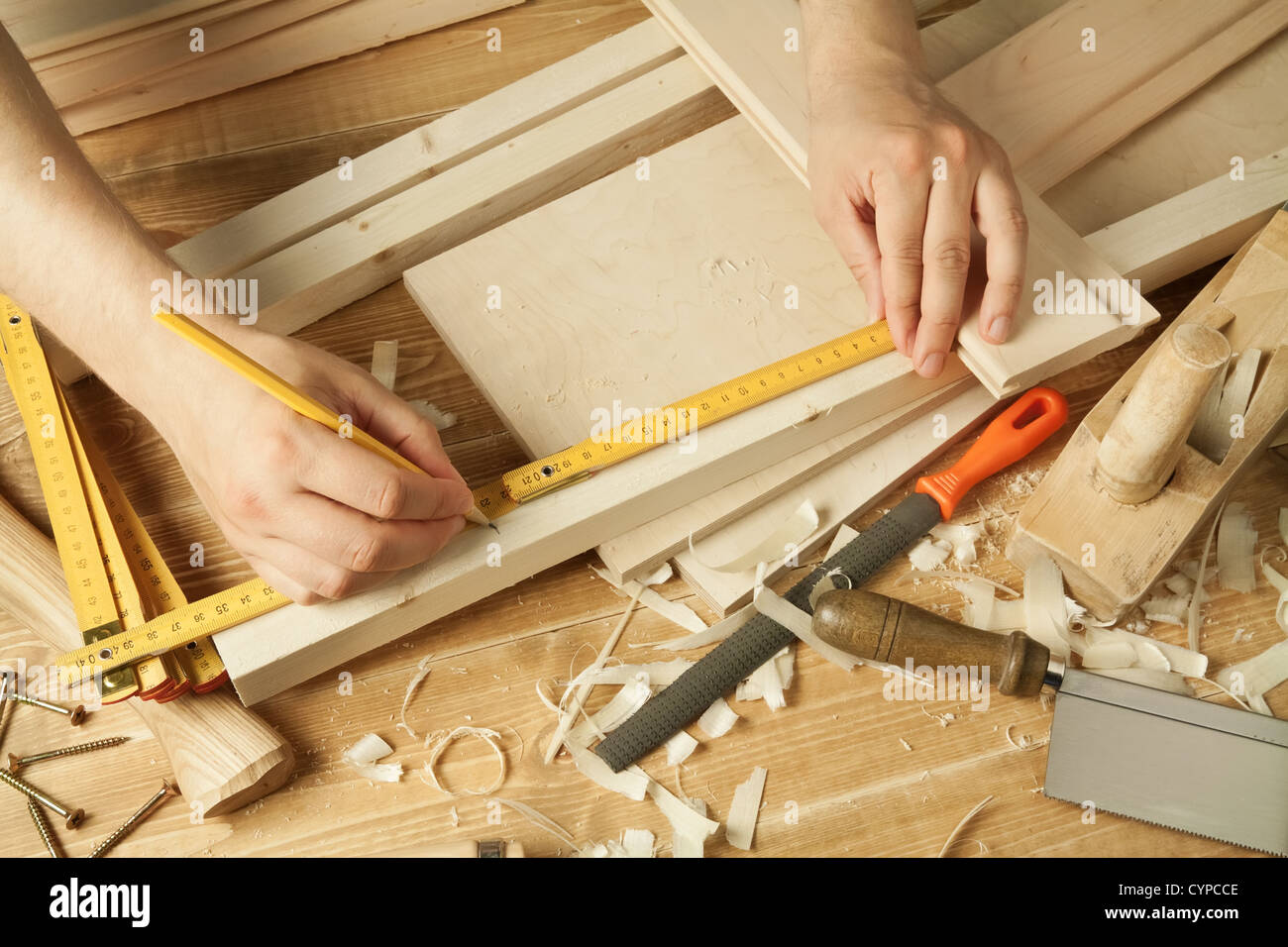 Atelier en bois avec la table d'outils. Les bras de l'homme la mesure. Banque D'Images