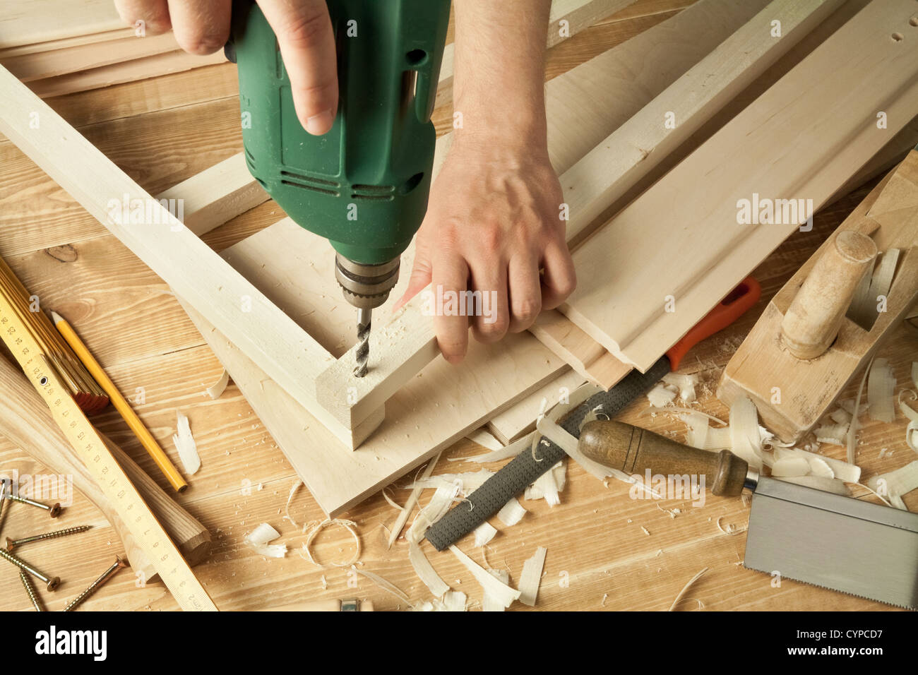 Atelier en bois avec la table d'outils. Man's arms drill planche. Banque D'Images
