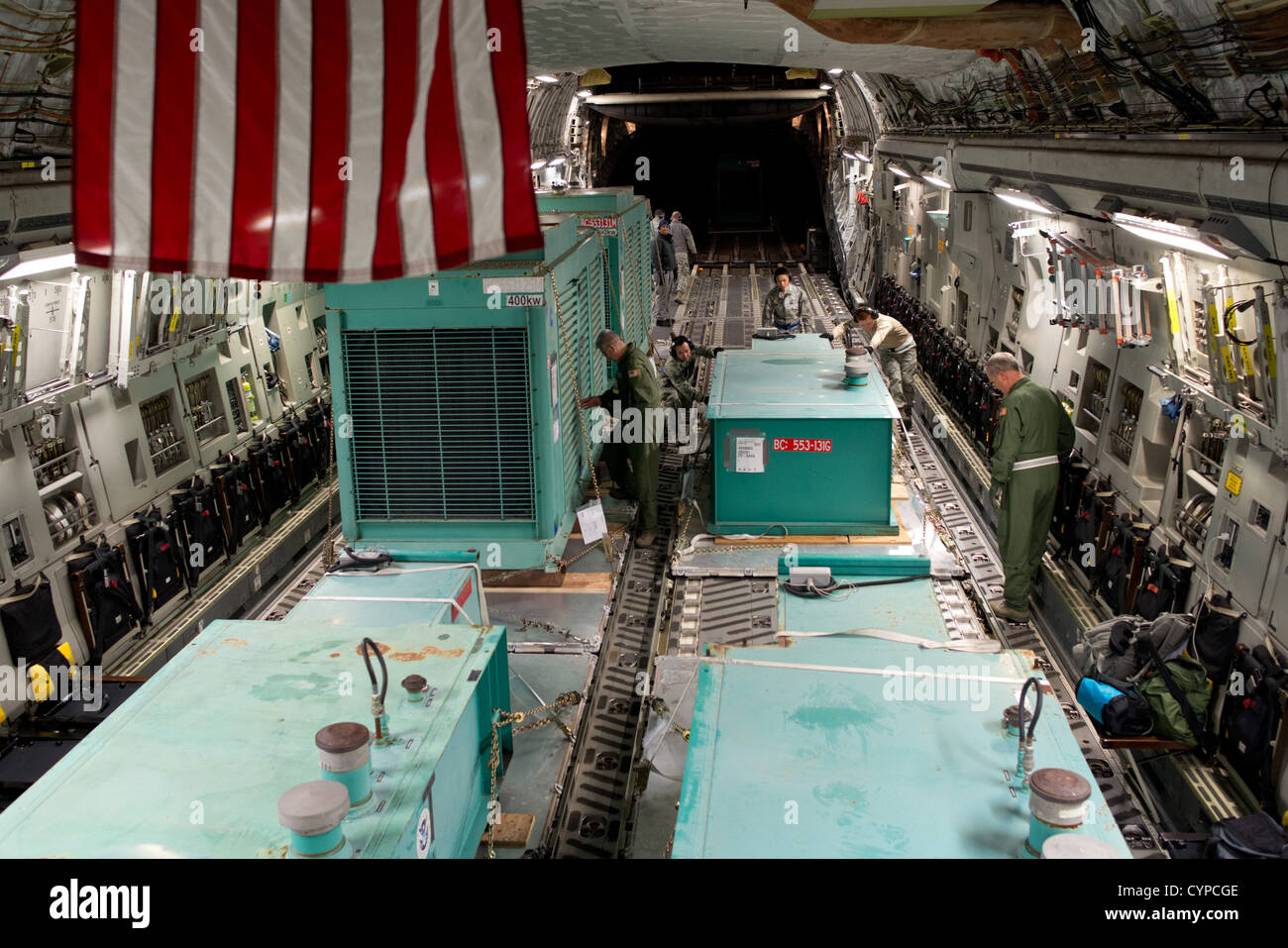Les aviateurs de Travis AFB et March ARB travaillent ensemble pour charger de gros générateurs et réservoirs de carburant de la FEMA sur un C-17 Globemaster pour les secours en cas de catastrophe en réponse à l'ouragan Sandy. Banque D'Images