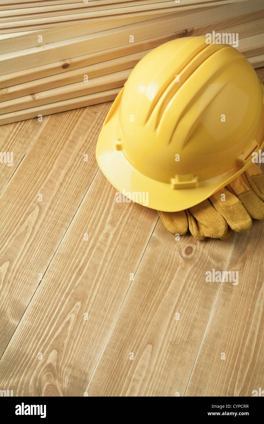 Arrière-plan de construction. Casque jaune sur un plancher en bois. Banque D'Images