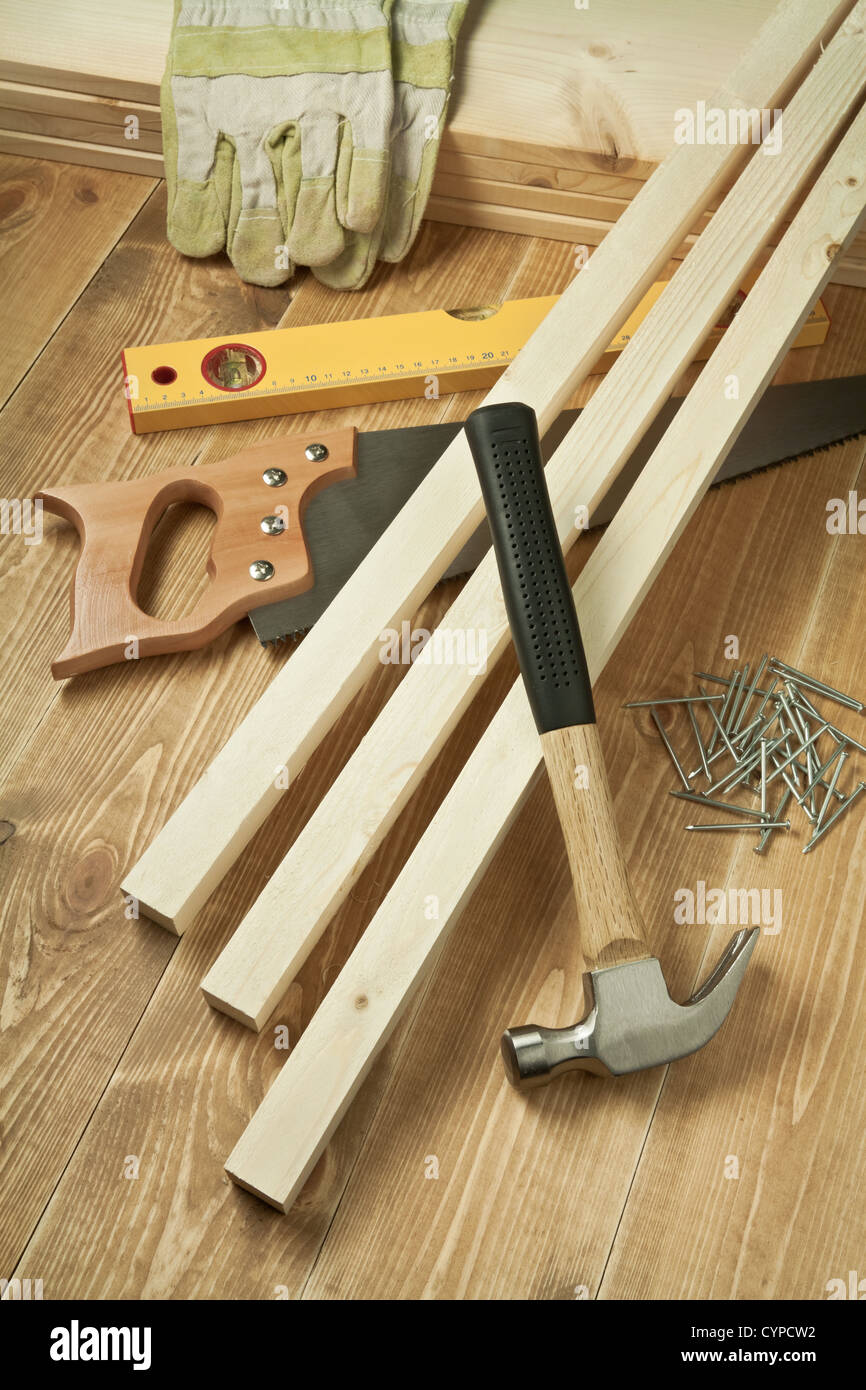 Marteau, scie, niveau, gants, bandes et des ongles sur plancher en bois Banque D'Images