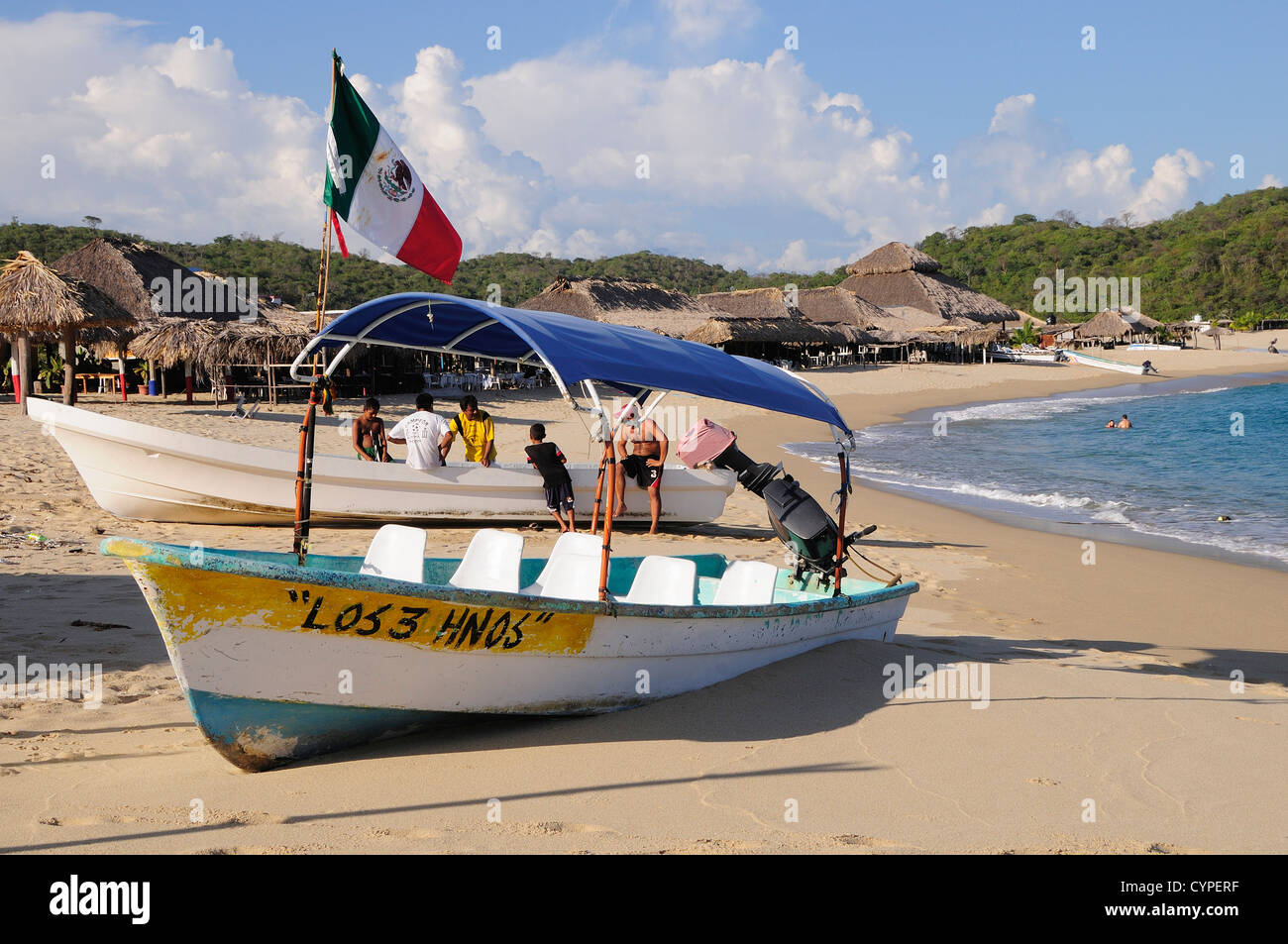 Mexique, Oaxaca, Huatulco, bateaux de pêche s'arrêta en face de la plage de sable de cabanes sur Bahia San Agustin sur la côte de l'Océan Pacifique Banque D'Images