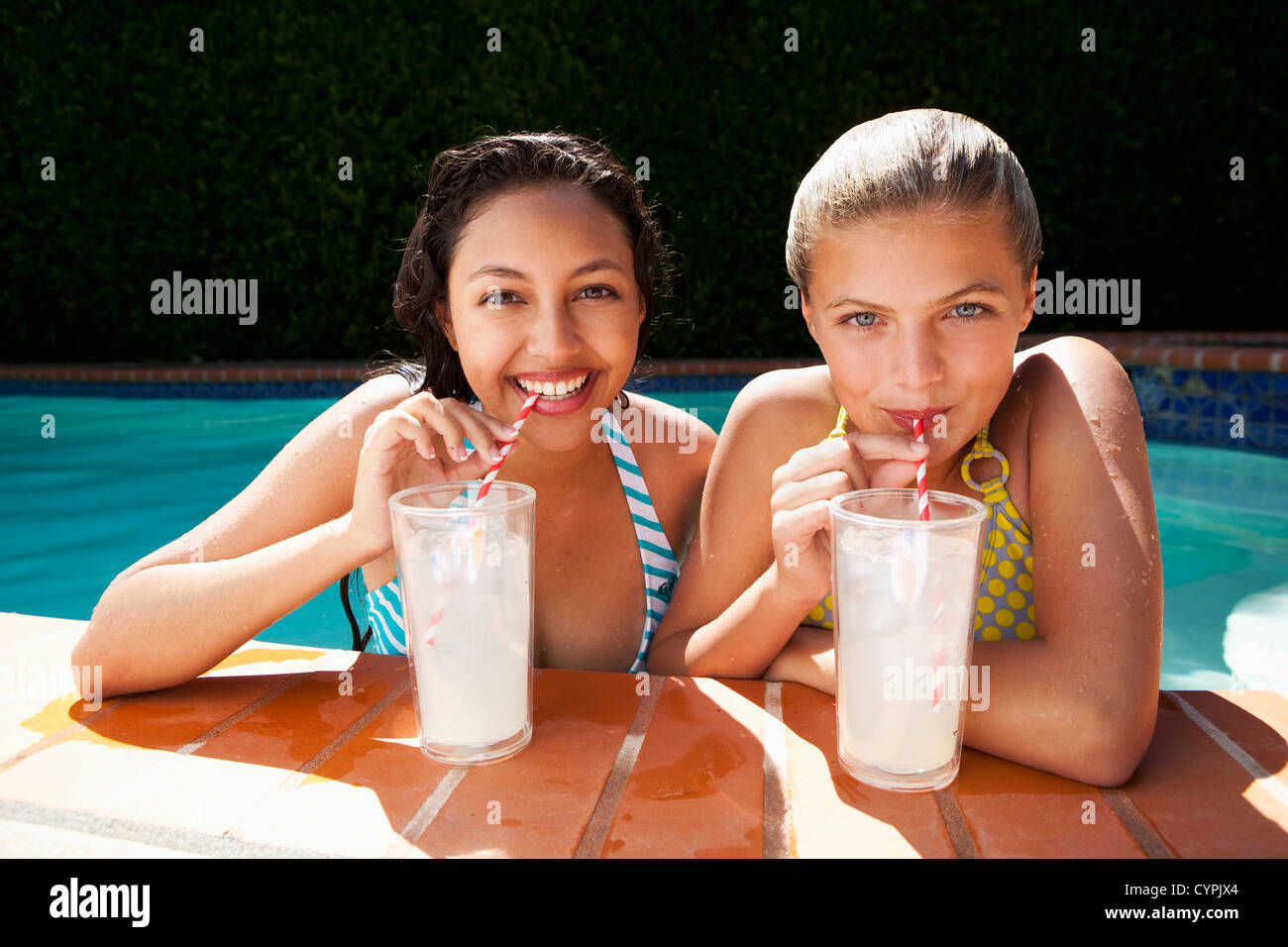 Les filles de boire de la limonade proche piscine Banque D'Images