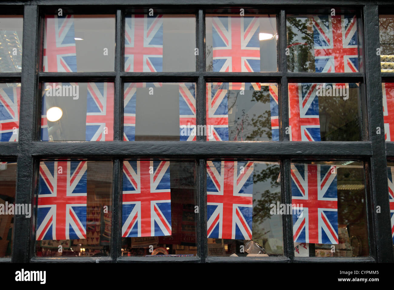 Rouge, blanc et bleu des drapeaux de l'Union (Union Jacks) sur des banderoles dans une fenêtre au Royaume-Uni. Banque D'Images